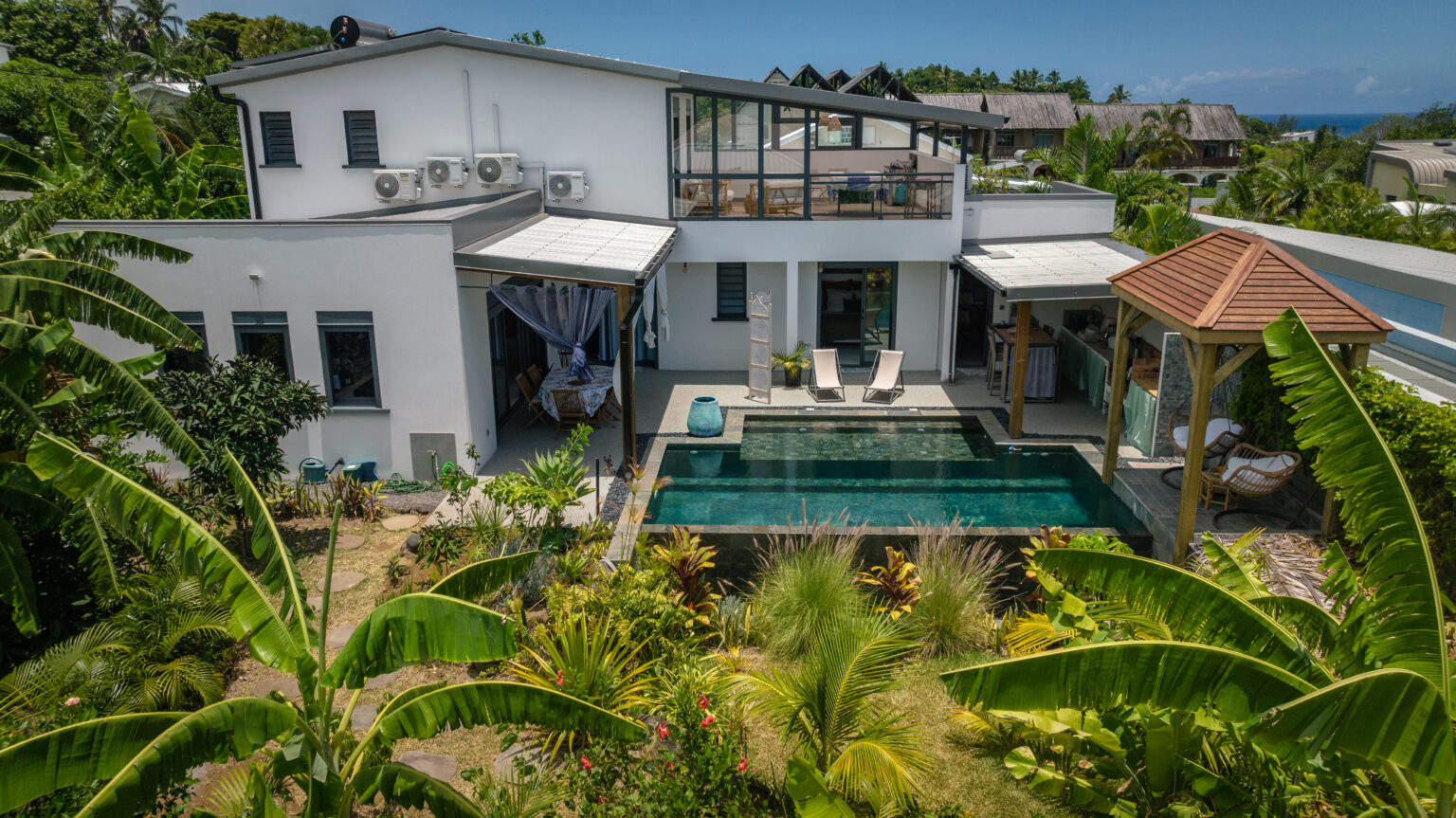 La maison Ti Oasis vue dans son ensemble, avec sa piscine à débordement et son jardin, à Manapany-les-Bains